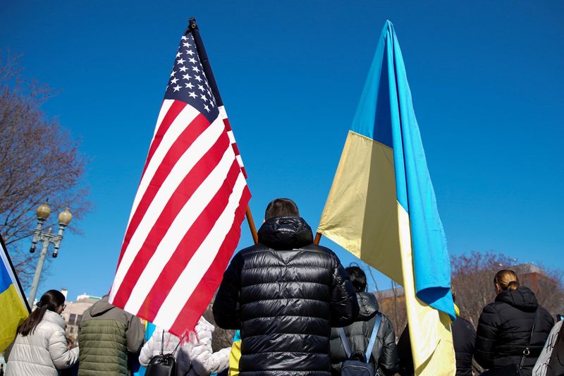 &copy; Reuters. FILE PHOTO: A demonstrator holds U.S. and Ukrainian flags during a "Stand with Ukraine" rally against the Russian invasion of Ukraine, in front of the White House in Washington, U.S., February 28, 2022. REUTERS/Elizabeth Frantz/File Photo