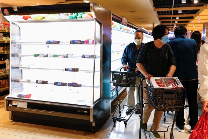 &copy; Reuters. 　３月３日、香港で新型コロナウイルスの感染者急増による人員不足から、地下鉄やバスは減便、スーパー大手は営業時間短縮に動いている。２日に香港のスーパーで撮影（２０２２年　ロ