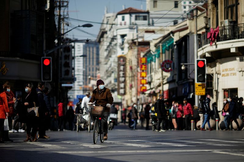 &copy; Reuters. FOTO DE ARCHIVO: Un hombre con mascarilla circula en bicicleta por una calle de Shanghái, China el 25 de febrero de 2022. REUTERS/Aly Song