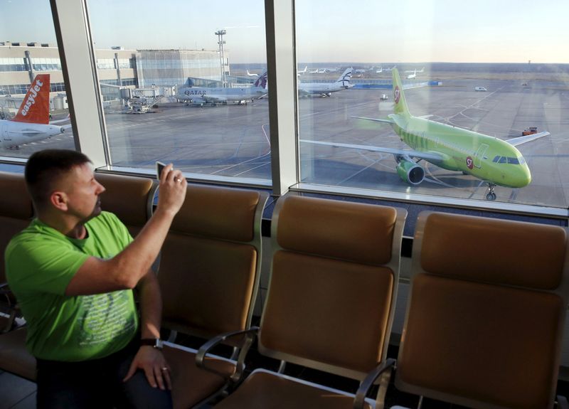 &copy; Reuters. FILE PHOTO: A man takes pictures, with a plane (R) of S7 airlines seen in the background, at Domodedovo airport outside Moscow, Russia, November 6, 2015. REUTERS/Maxim Zmeyev