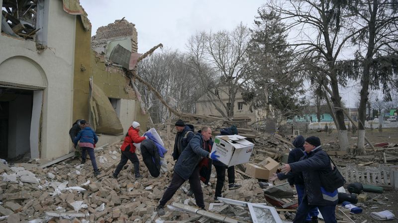 © Reuters. Moradores carregam ajuda humanitária armazenada em centro cultural que afirmam ter sido destruído por disparos de artilharia em Byshiv, na região de Kiev, na Ucrânia 
04/03/2022 REUTERS/Maksim Levin