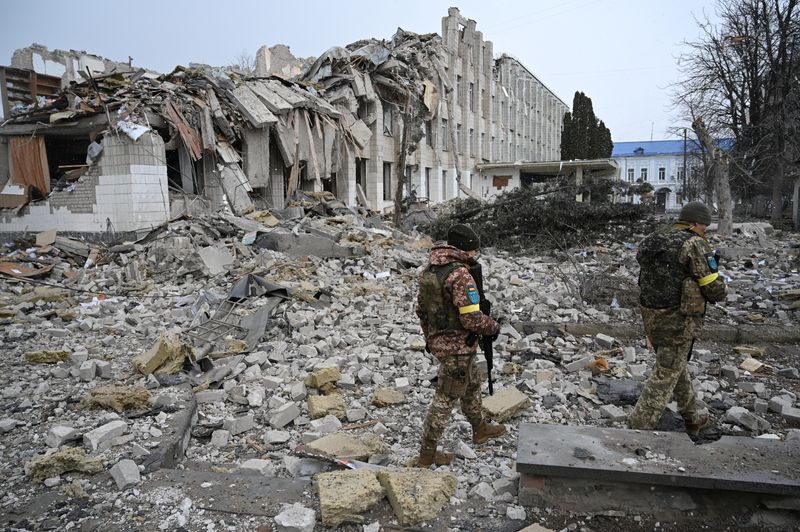 © Reuters. Ukrainian service members walk near a school building destroyed by shelling, as Russia's invasion of Ukraine continues, in Zhytomyr, Ukraine March 4, 2022. REUTERS/Viacheslav Ratynskyi