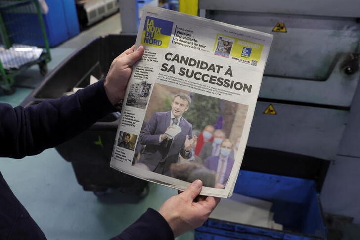 &copy; Reuters. Un empleado de una imprenta muestra una copia de la última edición del diario regional "La Voix du Nord", con el anuncio en portada de la candidatura presidencial del mandatario, Emmanuel Macron, en Marcq-en-Baroeul, Francia. 4 marzo 2022. REUTERS/Pasca