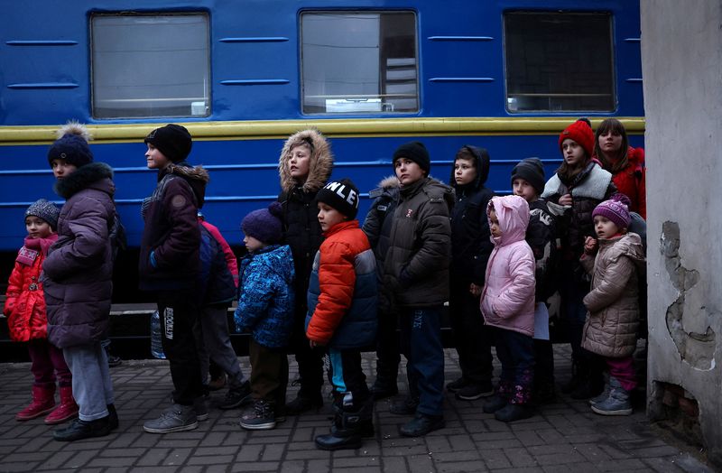 &copy; Reuters. A group of children evacuated from an orphanage in Zaporizhzhia wait to board a bus for their transfer to Poland after fleeing the ongoing Russian invasion at the main train station in Lviv, Ukraine, March 5, 2022.   REUTERS/Kai Pfaffenbach 