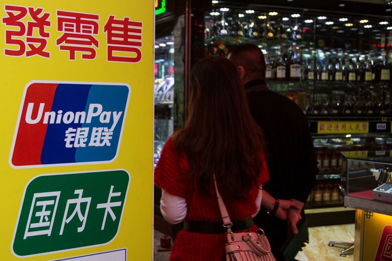 &copy; Reuters. FILE PHOTO - Chinese visitors walk past a sign for China UnionPay outside a pawnshop in Macau, in this picture taken November 20, 2013. Picture taken November 20, 2013.    REUTERS/Tyrone Siu/File Photo