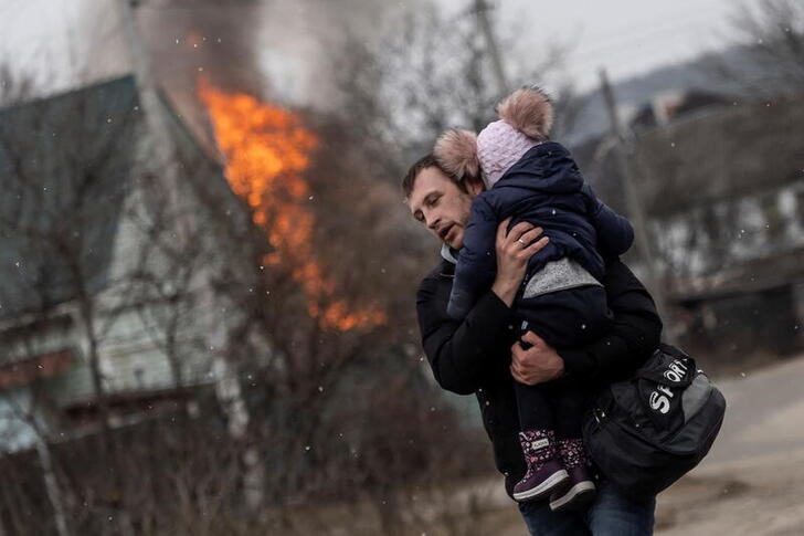 &copy; Reuters. Un hombre y un bebpe escapan de los bombardeos en la localidad de Irpín, cercana a Kiev, Ucrania. 6 marzo 2022. REUTERS/Carlos Barría
