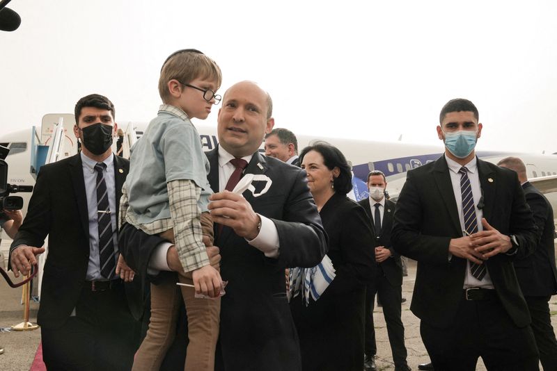 © Reuters. رئيس الوزراء الإسرائيلي نفتالي بينيت يرحب في مطار بن جوريون باسرائيل يوم الأحد بمجموعة من الأيتام القادمين من مدينة زيتومير الأوكرانية عقب الغزو الروسي. صورة لرويترز من ممثل لوكالات الأنباء.