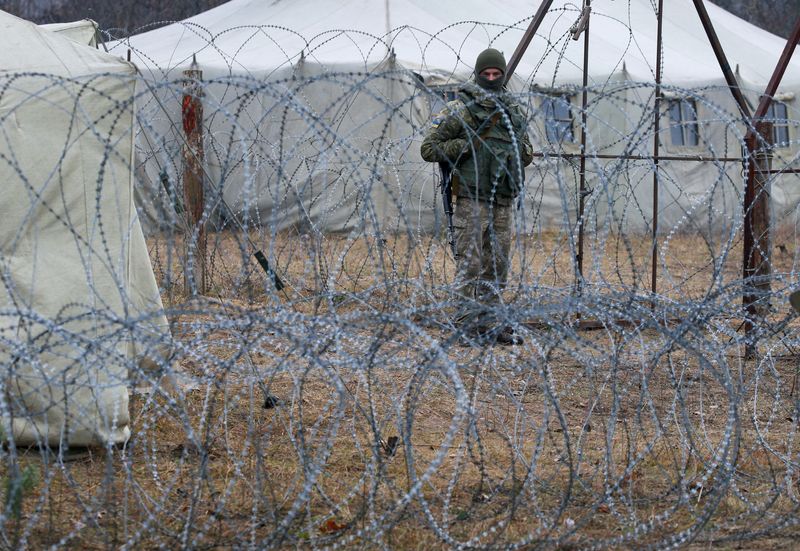 &copy; Reuters. جندي من حرس الحدود الأوكراني قرب الحاجز الحدودي مع روسيا البيضاء وبولندا في 16 نوفمبر تشرين الثاني 2021. رويترز