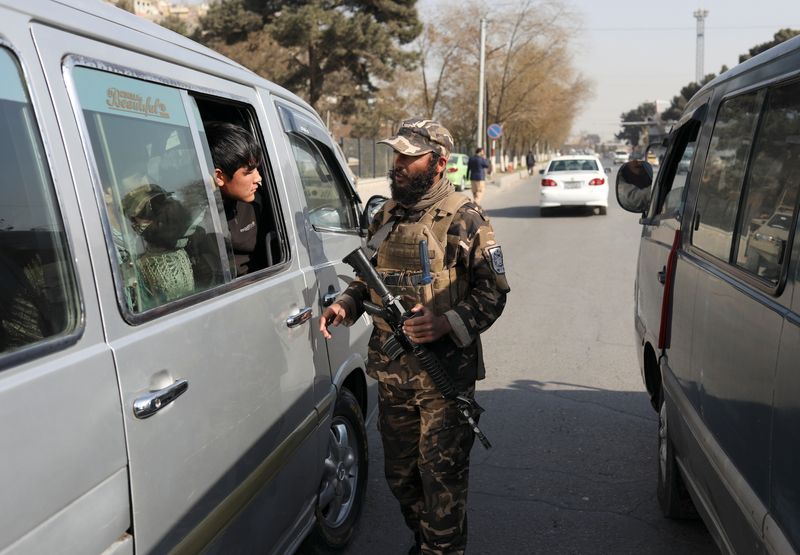 &copy; Reuters. FILE PHOTO: A Taliban fighter searches a car as he guards a checkpoint in Kabul, Afghanistan November 27, 2021. REUTERS/Ali Khara