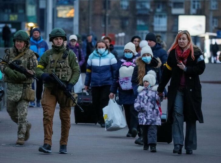 &copy; Reuters. Foto del lunes de fuerzas de seguridad escoltando a familias en un tren para ser evacuadas desde Kiev 
Mar 7, 2022. REUTERS/Gleb Garanich