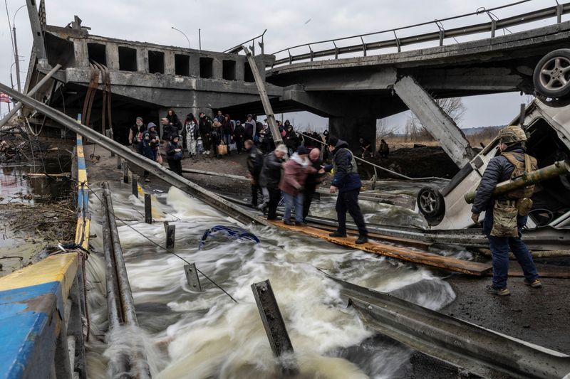 &copy; Reuters. Moradores atravessam ponte destruída ao deixarem cidade de Irpin, perto de Kiev, na Ucrânia
07/03/2022
REUTERS/Carlos Barria