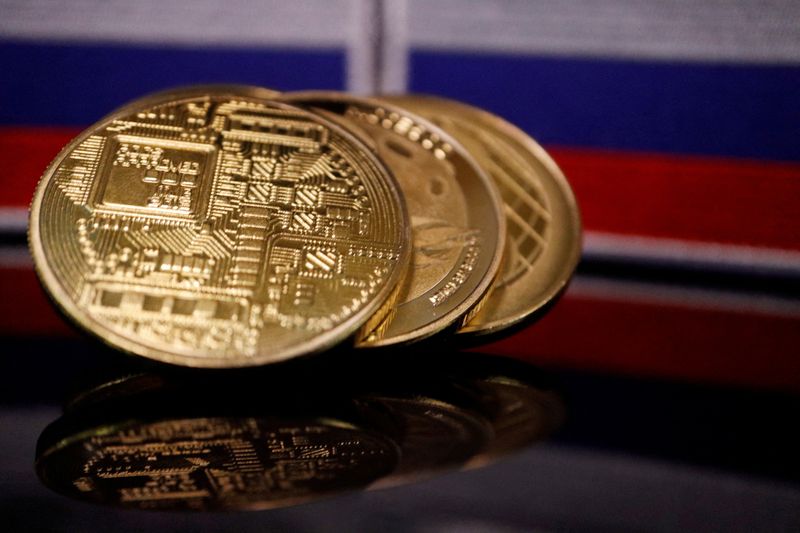 © Reuters. FILE PHOTO: Representations of cryptocurrencies are displayed in front of Russian flags in this picture illustration taken March 4, 2022. REUTERS/Florence Lo/File Photo