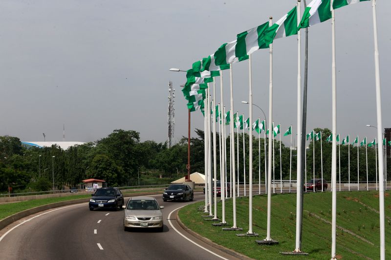 &copy; Reuters. FOTO DE ARCHIVO: Coches pasando junto a las banderas nacionales de Nigeria durante el Día de la Democracia en Abuja, Nigeria, 12 de junio de 2021. REUTERS/Afolabi Sotunde