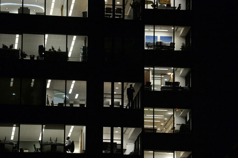 &copy; Reuters. Diversi lavoratori in un ufficio della City of London durante la notte. REUTERS/Mary Turner