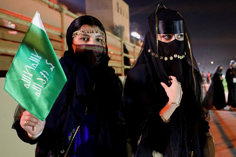 © Reuters. امرأة سعودية تمسك العلم السعودي احتفالا بذكرى يوم التأسيس في الرياض يوم 22 فبراير شباط 2022. تصوير: أحمد يسري - رويترز