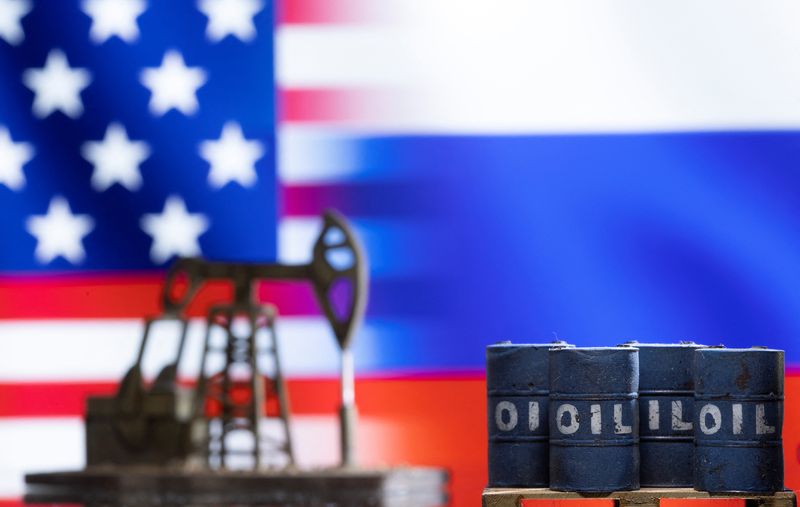 © Reuters. Models of oil barrels and a pump jack are seen in front of displayed U.S. and Russia flag colours in this illustration taken March 8, 2022. REUTERS/Dado Ruvic/Illustration
