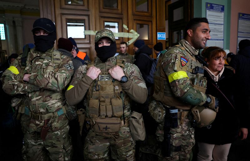 &copy; Reuters.  ３月７日、ウクライナに到着した外国人志願者の一部は、「大義」に惹かれたと話す。写真は５日、リビウの駅で前線に向かう列車を待つベン・グラントさんら英国からの義勇兵（２０２