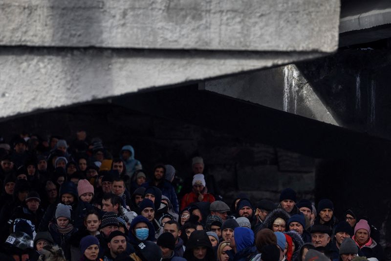 &copy; Reuters. People wait below a destroyed bridge to cross a river as they flee from advancing Russian troops whose attack on Ukraine continues in the town of Irpin outside Kyiv, Ukraine, March 8, 2022. REUTERS/Thomas Peter    