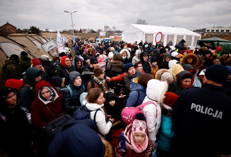 &copy; Reuters. FILE PHOTO: People wait to board a bus after fleeing the Russian invasion of Ukraine, at the border checkpoint in Medyka, Poland, March 8, 2022. REUTERS/Yara Nardi