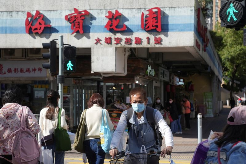 © Reuters. People wearing face masks cross a street, following the coronavirus disease (COVID-19) outbreak, in Hong Kong, China March 9, 2022. REUTERS/Lam Yik