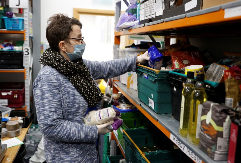 &copy; Reuters. FILE PHOTO: A volunteer at the North Enfield Foodbank Charity packs a bag of groceries and other household items for distribution in Enfield as the spread of coronavirus disease (COVID-19) continues in London, Britain March 24, 2020. REUTERS/John Sibley