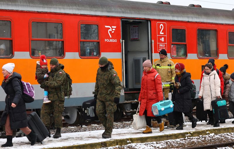 &copy; Reuters. جنديان من الجيش البولندي يساعدون الناس على ركوب قطار إلى كراكوف بعد عبور الحدود من أوكرانيا إلى بولندا بعد الفرار من الغزو الروسي لأوكرانيا