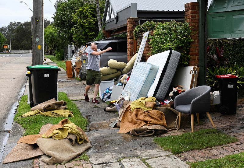 &copy; Reuters. Homem remexe em pertences em casa afetada pelas enchentes no subúrbio de Sydney, na Austrália
09/03/2022 REUTERS/Jaimi Joy