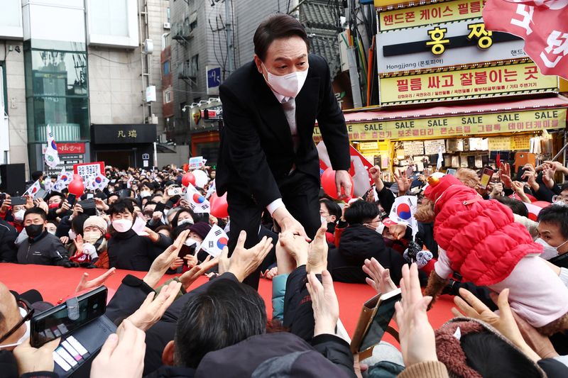 &copy; Reuters. FILE PHOTO: Yoon Suk-yeol, the presidential election candidate of South Korea's main opposition People Power Party (PPP), shakes hands with his supporters during his election campaign in Seoul, South Korea, March 1, 2022. REUTERS/Kim Hong-Ji/File Photo