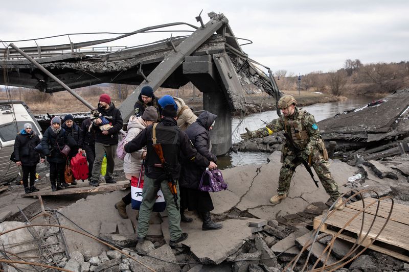 &copy; Reuters. People flee near a destroyed bridge to cross Irpin River as Russia's invasion on Ukraine continues, in Irpin outside Kyiv, Ukraine, March 9, 2022. REUTERS/Mikhail Palinchak