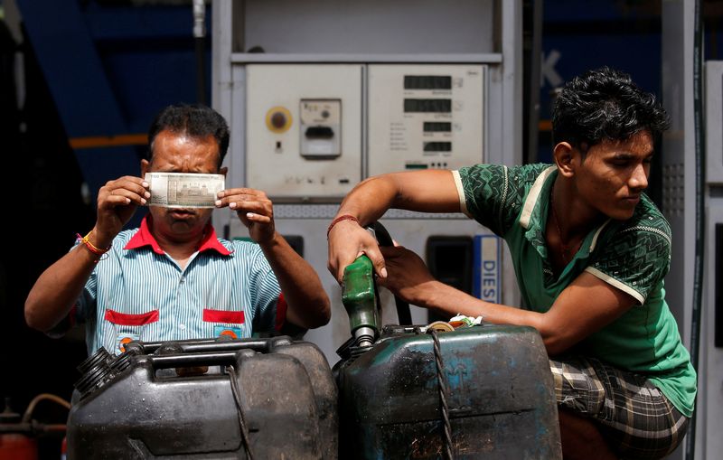 &copy; Reuters. A worker checks a 500 Indian rupee note as a man fills diesel in containers at a fuel station in Kolkata, India, August 14, 2018. REUTERS/Rupak De Chowdhuri/Files