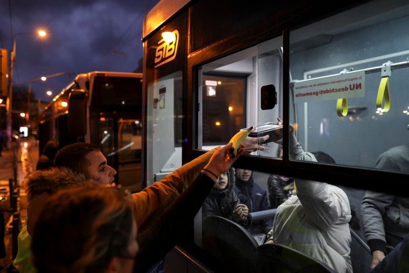 &copy; Reuters. FOTO DE ARCHIVO: Voluntarios ofrecen comida a las personas que huyen de Ucrania tras la invasión rusa, mientras esperan en un autobús cerca de la estación de tren del Norte en Bucarest, Rumanía, 9 de marzo de 2022. Inquam Photos/Octav Ganea vía REUTE