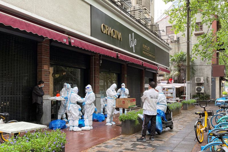 © Reuters. Workers dress up in protective suits amid the coronavirus disease (COVID-19) outbreak in Shanghai, China April 23, 2022. REUTERS/Brenda Goh