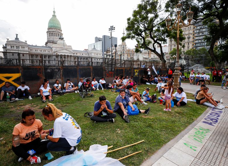 &copy; Reuters. FILE PHOTO - Demonstrators sit near the National Congress as the senate debates the government's agreement with the International Monetary Fund (IMF), in Buenos Aires, Argentina March 17, 2022. REUTERS/Agustin Marcarian