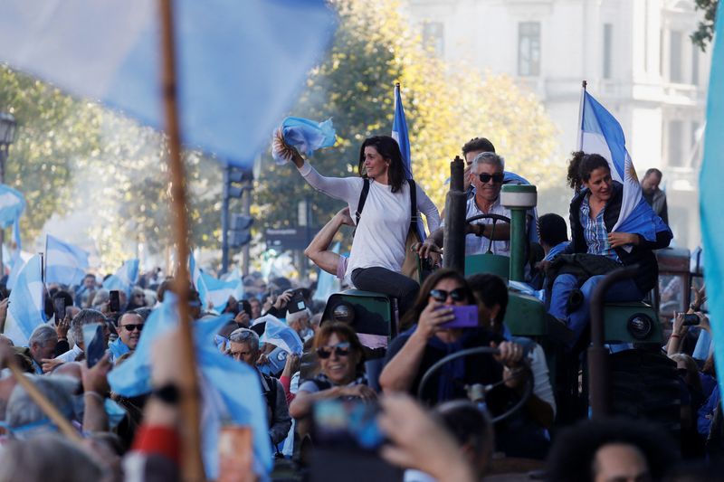 &copy; Reuters. People hold Argentine flags as farmers ride tractors at Plaza de Mayo to protest new export taxes on farm goods applied by President Alberto Fernandez's administration, in Buenos Aires, Argentina April 23, 2022. REUTERS/Agustin Marcarian
