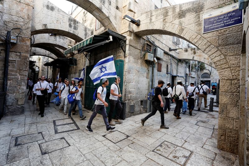 © Reuters. رجال يهود يحملون الأعلام الإسرائيلية أثناء مشاركتهم في مسيرة في زقاق داخل مدينة القدس  يوم الأحد. تصوير: عمار عوض - رويترز.