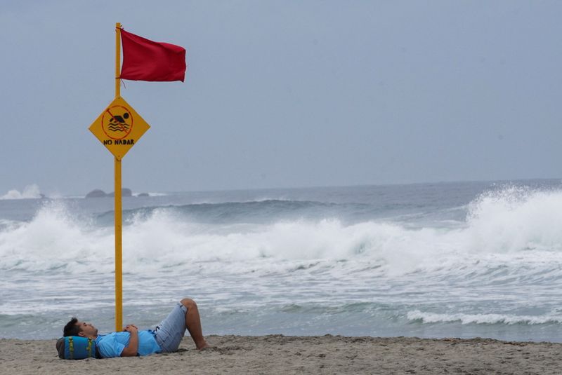 © Reuters. A man rests on a beach as Hurricane Agatha barrels toward the southern coast of Mexico, in Puerto Escondido in Oaxaca state, Mexico, May 29, 2022. REUTERS/Jose de Jesus Cortes