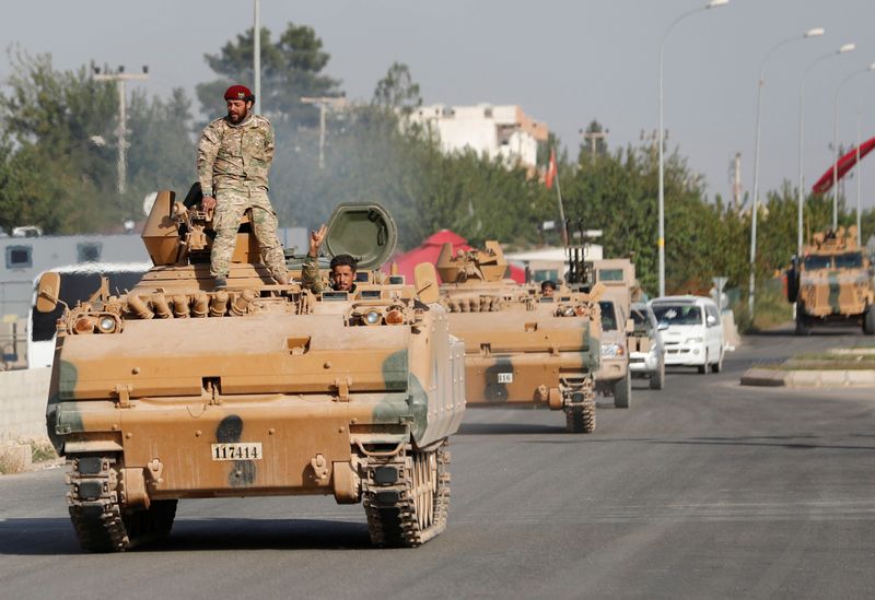 &copy; Reuters. أفراد من الجيش الوطني السوري، الذي يعرف باسم الجيش السوري الحر، يقودون مركبات مصفحة في بلدة رأس العين الحدودية التركية في صورة من أرشيف روي
