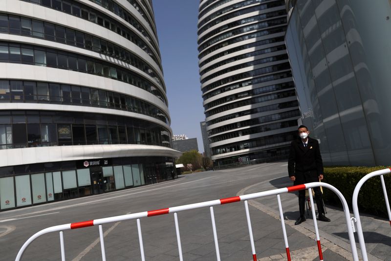 &copy; Reuters. حارس أمن يضع كمامة يقف بجوار مجمع إداري في بكين يوم السادس من أبريل نيسان 2022. تصوير: تينجشو وانغ - رويترز