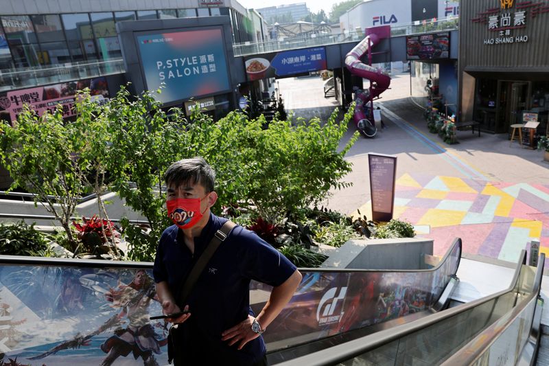 &copy; Reuters. رجل يضع كمامة في مجمع تسوق في بكين يوم 20 مايو أيار 2022. تصوير: تينجشو وانغ - رويترز