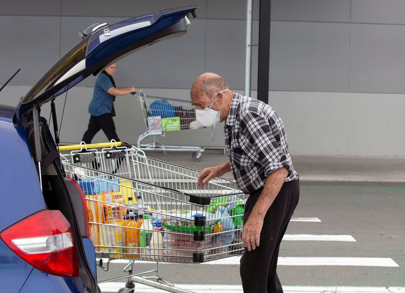 &copy; Reuters. FILE PHOTO: Brian Green, 76, wears a mask as he takes out products from his supermarket shopping cart and loads them into his car outside Pak'nSave supermarket amid the spread of the coronavirus disease (COVID-19) in Christchurch, New Zealand, March 23, 2