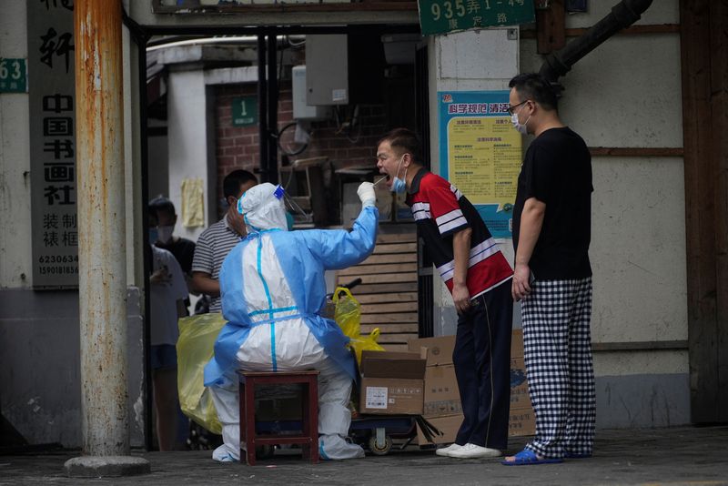 &copy; Reuters. Un trabajador médico recoge una muestra de hisopo de un hombre en una calle durante el confinamiento, en medio del brote de la enfermedad por coronavirus (COVID-19), en Shanghái, China. 30 de mayo de 2022. REUTERS/Aly Song