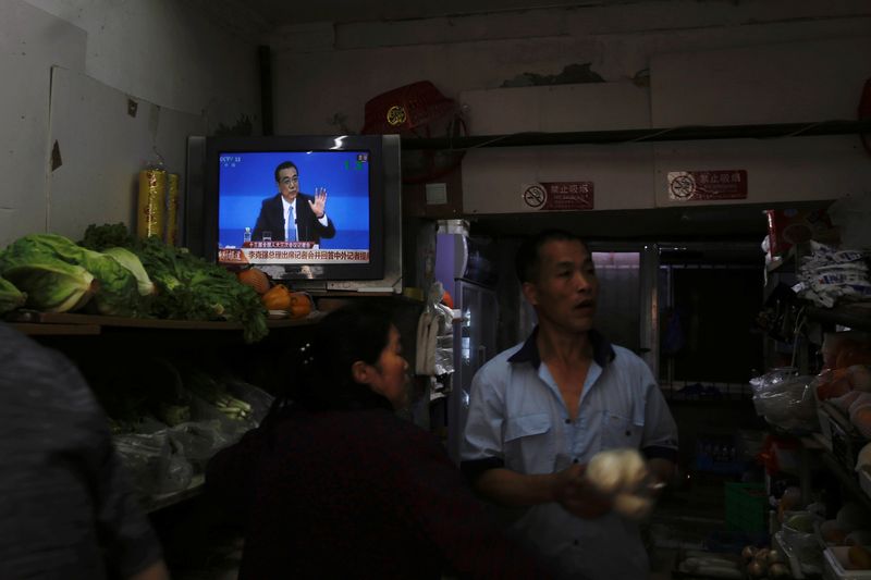 &copy; Reuters. FILE PHOTO: A television showing a news conference by Chinese Premier Li Keqiang after the closing session of the National People's Congress (NPC), is seen inside a vegetables store in Beijing, China May 28, 2020.  REUTERS/Tingshu Wang