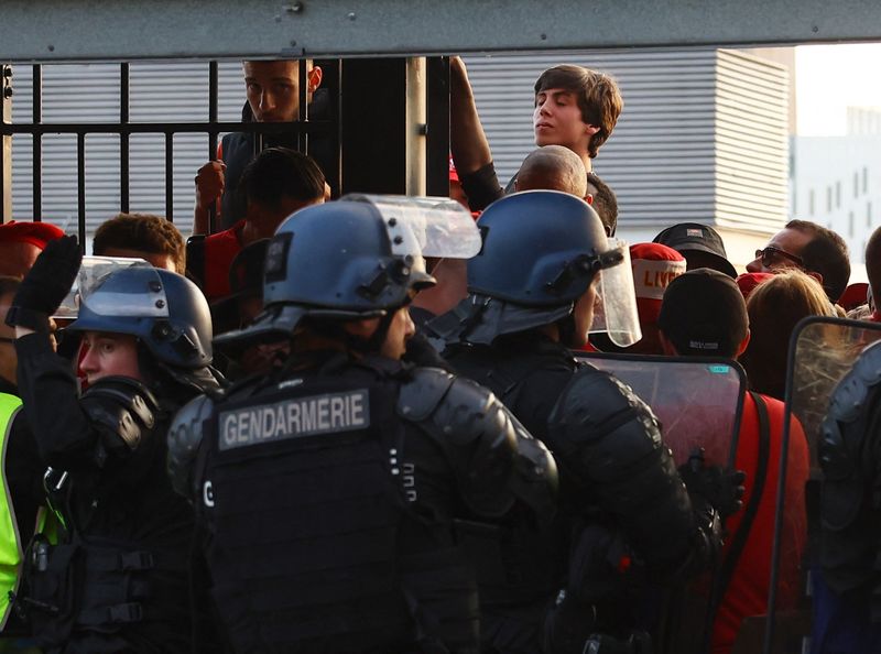 &copy; Reuters. Un aficionado mira a través de una valla mientras los hinchas son detenidos por agentes de policía en los tornos dentro del estadio durante el partido del Liverpool contra el Real Madrid en el Stade de France, Saint-Denis, cerca de París, Francia, 28 d