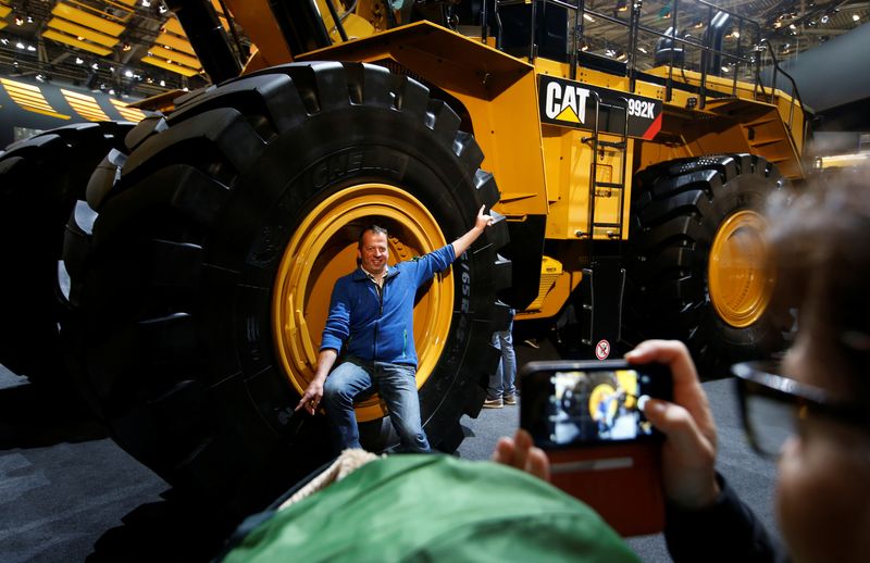 &copy; Reuters. Un hombre posa en una rueda de una excavadora Caterpillar en la feria &apos;Bauma&apos; de Múnich