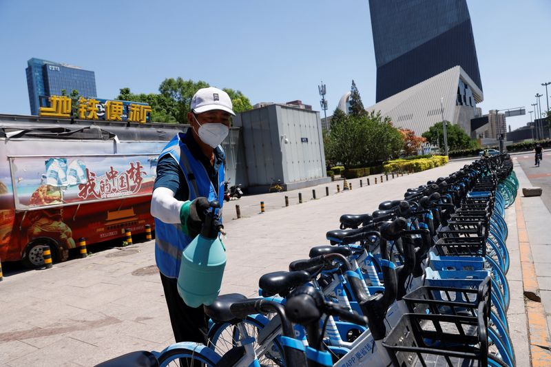 &copy; Reuters. A worker wearing a face mask sprays disinfectant on shared bicycles outside a subway station in the Central Business District (CBD), amid the coronavirus disease (COVID-19) outbreak in Beijing, China May 30, 2022. REUTERS/Carlos Garcia Rawlins