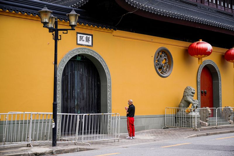 &copy; Reuters. A man prays outside a closed temple during lockdown, amid the coronavirus disease (COVID-19) outbreak, in Shanghai, China, May 30, 2022. REUTERS/Aly Song     