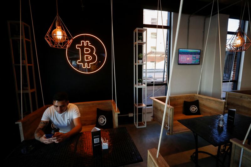 &copy; Reuters. 　５月３０日、アルゼンチンの首都ブエノスアイレスの繁華街にあるカフェ「クリプトステーション」では、暗号資産（仮想通貨）相場をリアルタイム表示するスクリーンや「ビットコイン