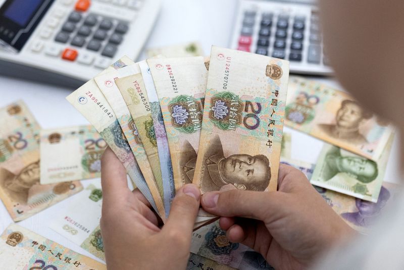 &copy; Reuters. Woman holds Chinese Yuan banknotes in this illustration taken May 30, 2022. REUTERS/Dado Ruvic/Illustration