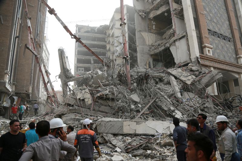 © Reuters. عمال الإنقاذ في موقع انهيار مبنى مكون من عشرة طوابق في آبادان يوم 23 مايو أيار 2022. صورة لرويترز من وكالة أنباء غرب آسيا. 