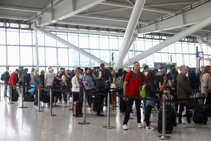 &copy; Reuters. FILE PHOTO: Passengers queue to enter airport security ahead of the Easter Bank Holiday weekend, at Terminal 5 of Heathrow Airport, in London, Britain, April 14, 2022. REUTERS/Hannah McKay